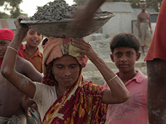 Woman carrying large bowl on her head