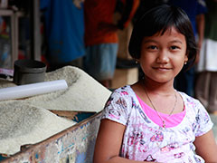 Smiling girl in front of bins of rice